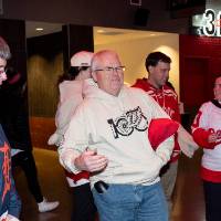 Two GVSU alum picking up sweatshirts and chatting with employee manning the merch table